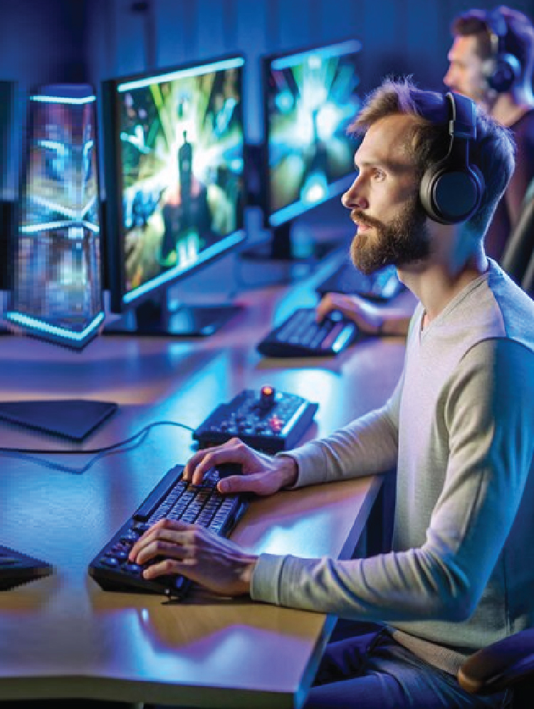 two men wearing headphones sitting infront of computer screen